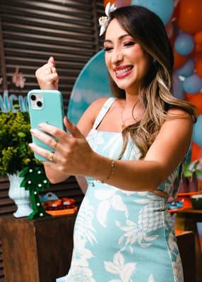 Gestante sorrindo com iFraldas no celular