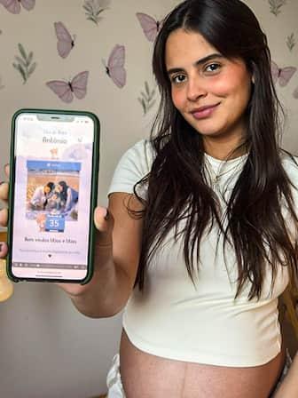 Gestante de vestido branco com celular
