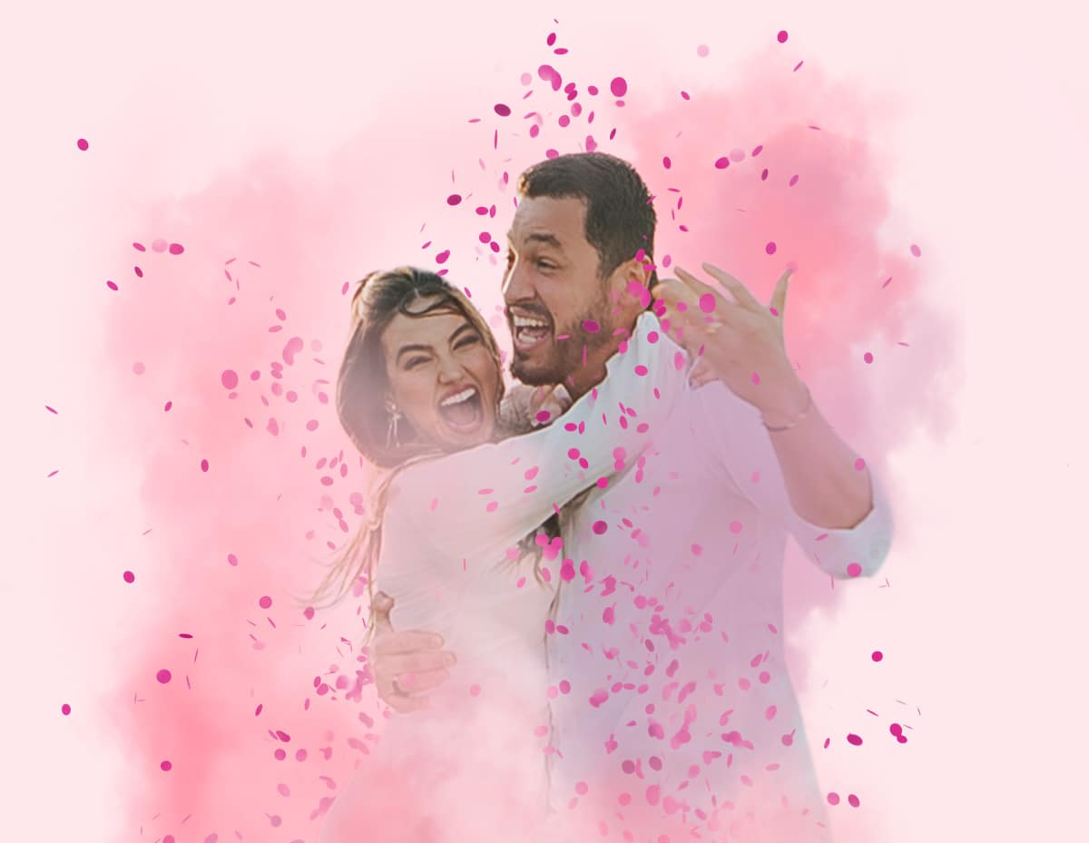 Casal feliz comemorando chá revelação de menina com confetes rosa